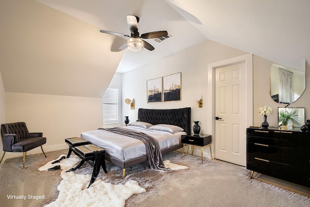 bedroom featuring lofted ceiling, light colored carpet, visible vents, baseboards, and a ceiling fan