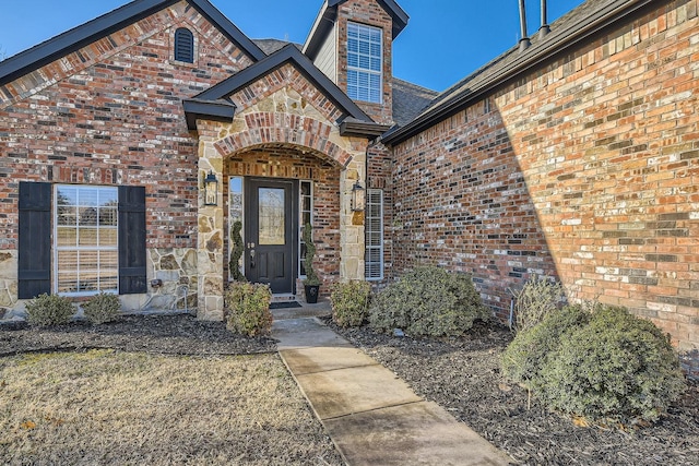 view of exterior entry featuring brick siding