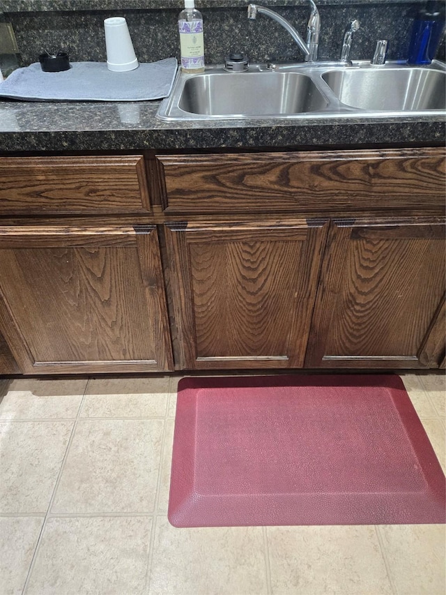 interior details featuring dark countertops, a sink, and dark brown cabinets