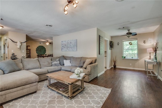 living area with baseboards, ceiling fan, visible vents, and wood finished floors