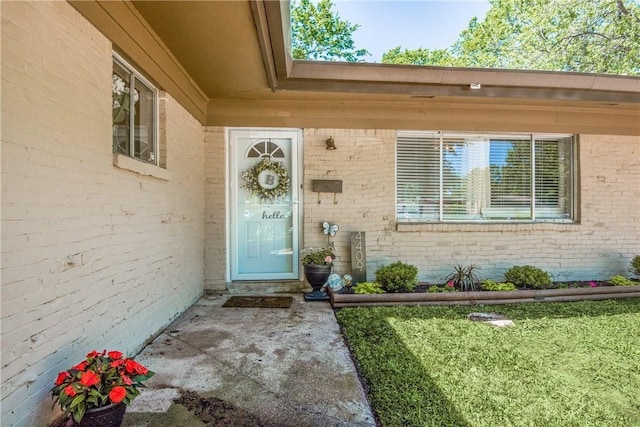 entrance to property featuring brick siding