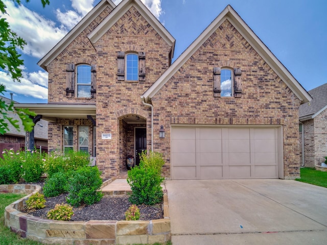 view of front facade with a garage, driveway, and brick siding