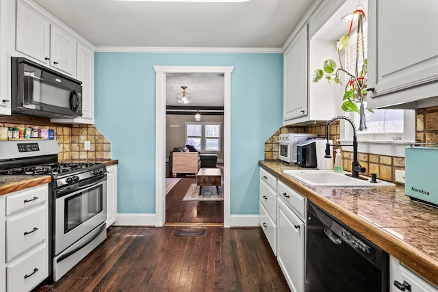 kitchen with dark wood-style flooring, a sink, white cabinets, black appliances, and crown molding