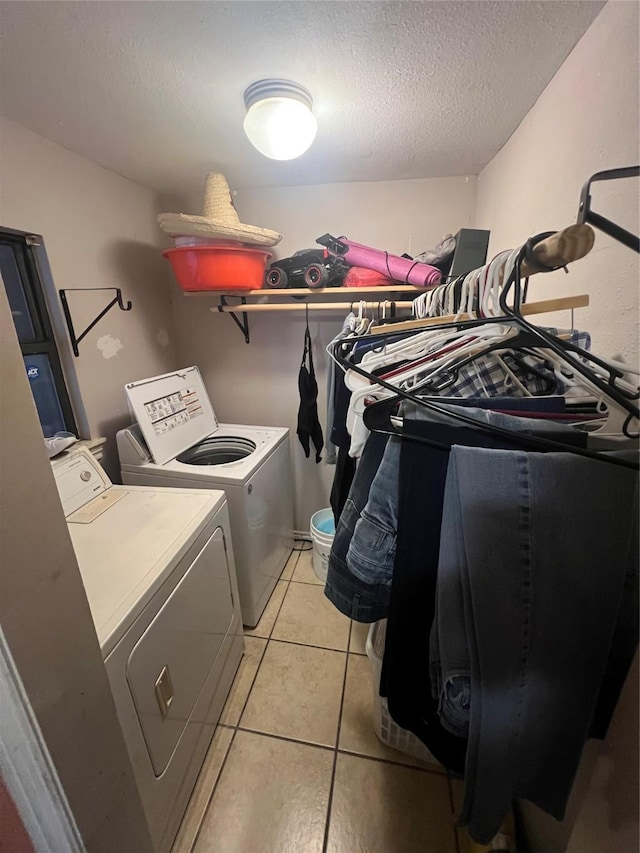 laundry room with light tile patterned floors, laundry area, a textured ceiling, and independent washer and dryer