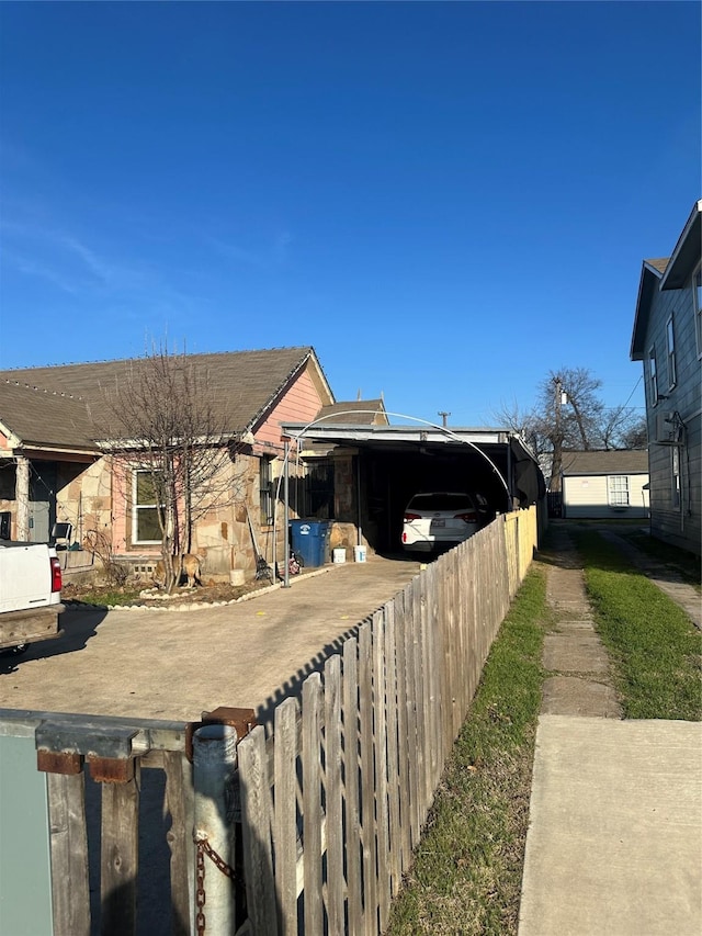 view of home's exterior with a carport and fence