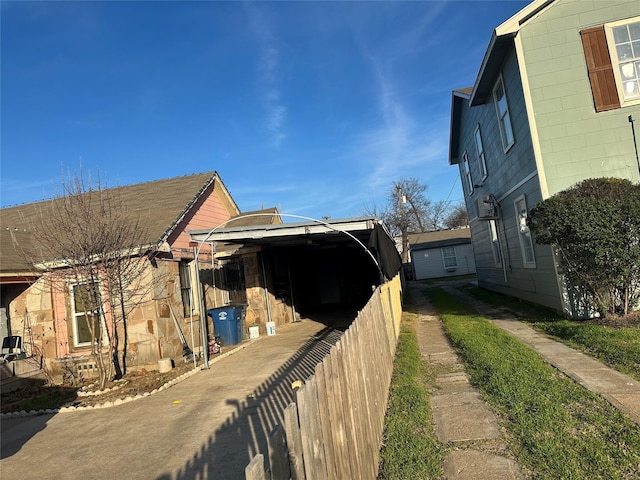 view of side of property featuring concrete block siding and fence