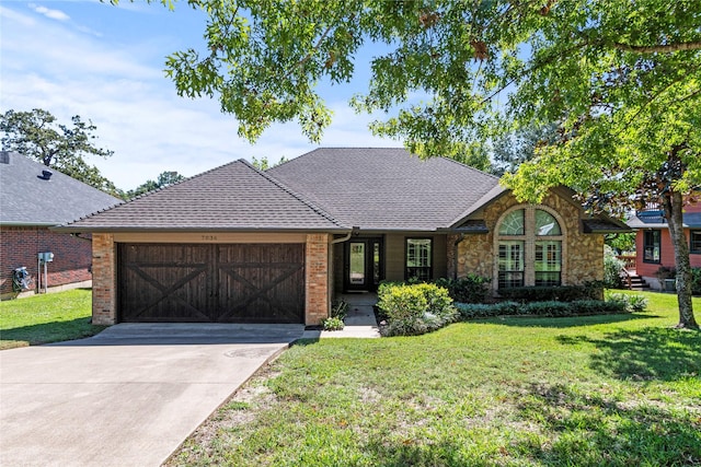 view of front of property featuring an attached garage, concrete driveway, stone siding, roof with shingles, and a front yard