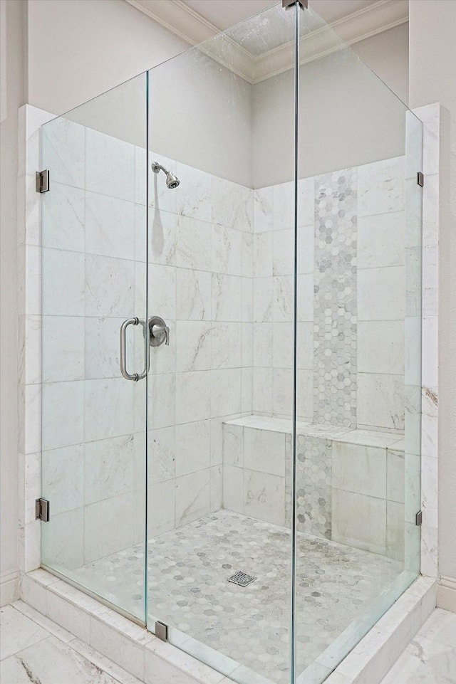 full bath with ornamental molding, marble finish floor, and a shower stall