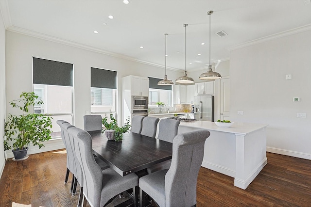 dining space featuring baseboards, dark wood-type flooring, visible vents, and crown molding