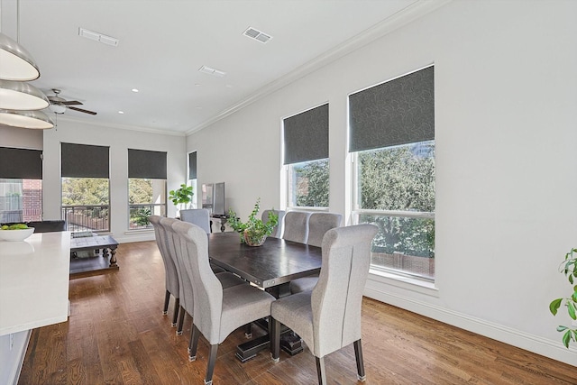 dining room featuring plenty of natural light, crown molding, visible vents, and wood finished floors