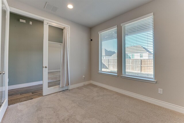 empty room with carpet, baseboards, and vaulted ceiling