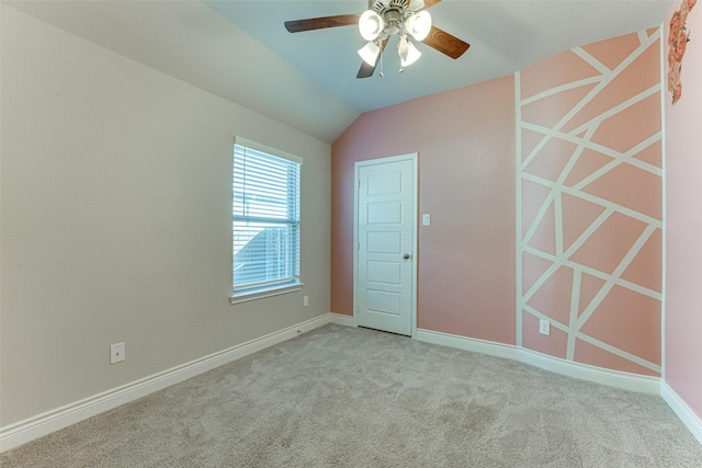 unfurnished room with lofted ceiling, baseboards, a ceiling fan, and light colored carpet