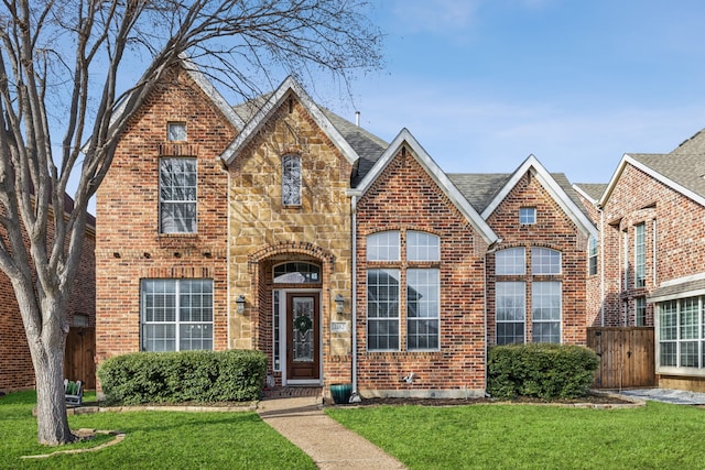 view of front of property with stone siding, a front lawn, and brick siding