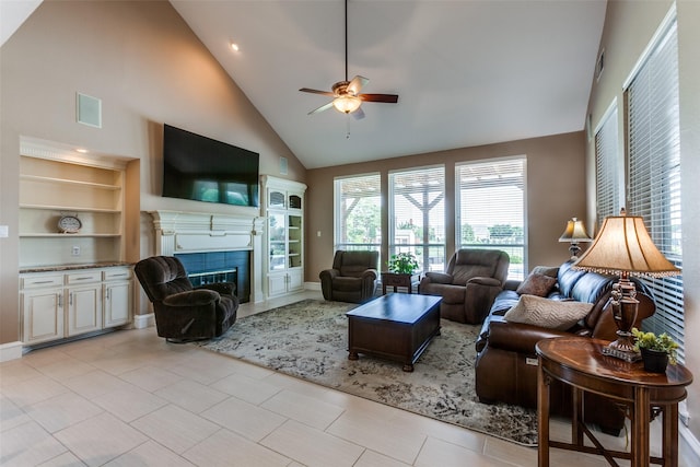 living room featuring ceiling fan, high vaulted ceiling, a tiled fireplace, and visible vents