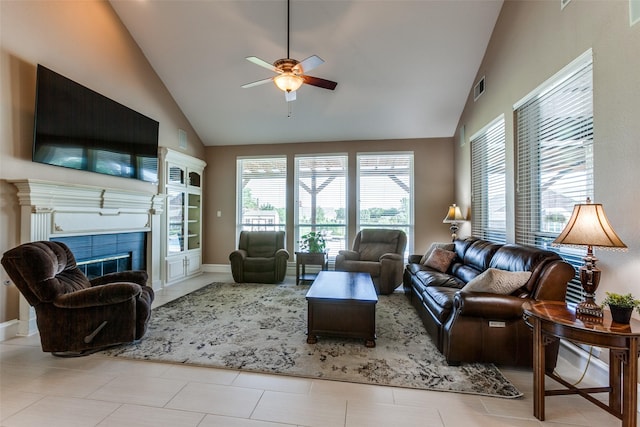 living room featuring high vaulted ceiling, a wealth of natural light, a fireplace, and visible vents