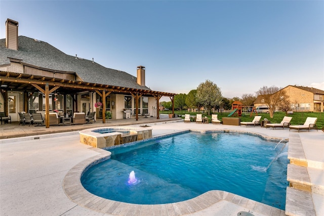 view of pool with a pool with connected hot tub, a patio area, playground community, and an outdoor hangout area