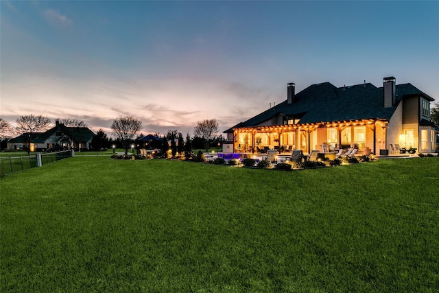 yard at dusk with a patio, fence, and a pergola