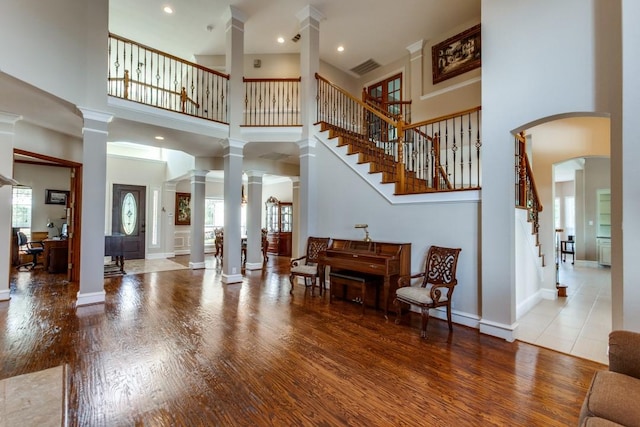 entryway featuring stairs, wood finished floors, decorative columns, and baseboards