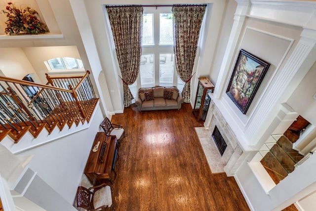 sitting room featuring stairs, visible vents, a fireplace with flush hearth, and wood finished floors