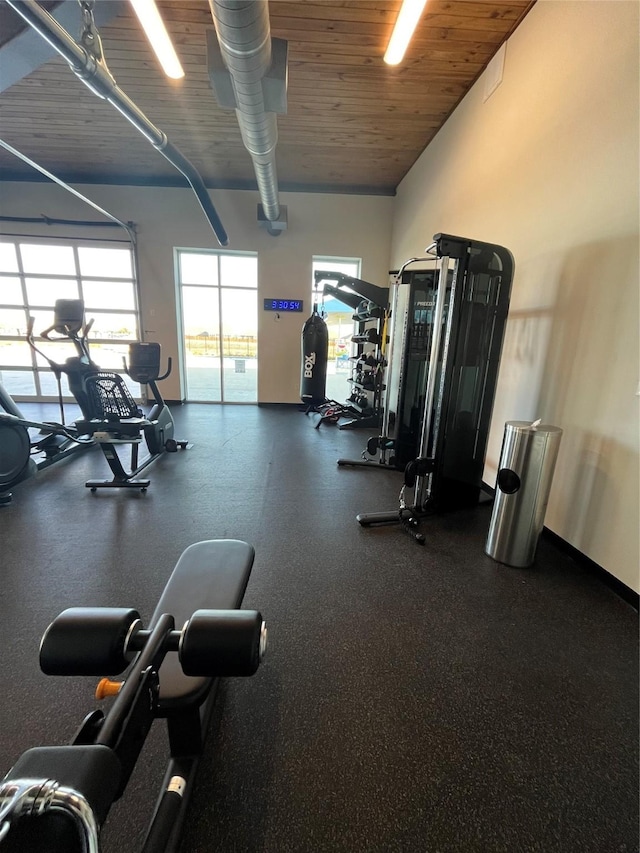 workout area with a garage, wood ceiling, and vaulted ceiling