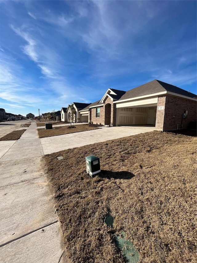 view of front of property with driveway, a garage, and brick siding