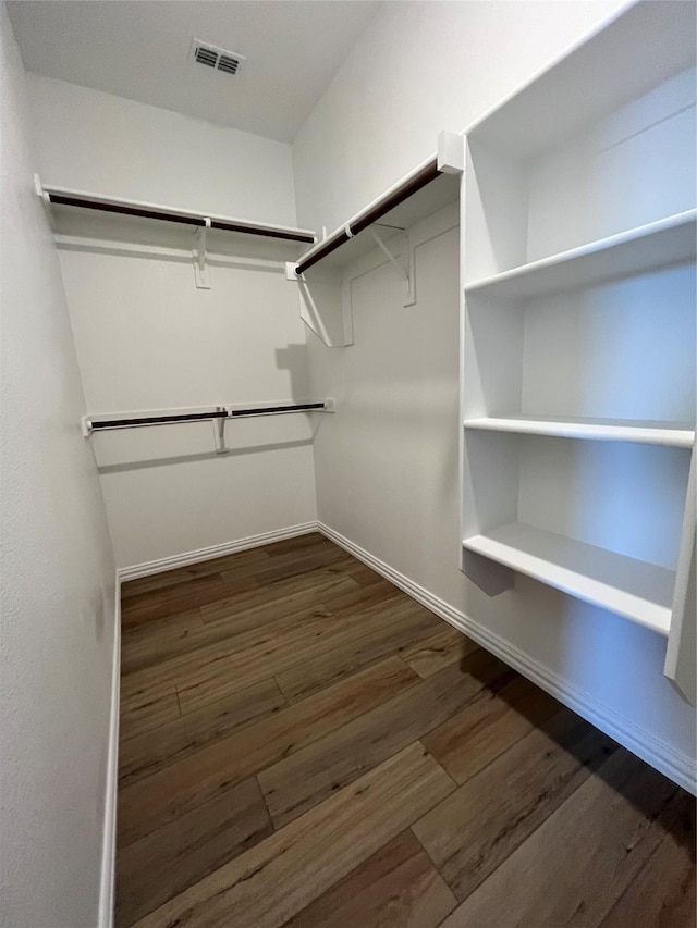 spacious closet featuring dark wood finished floors and visible vents