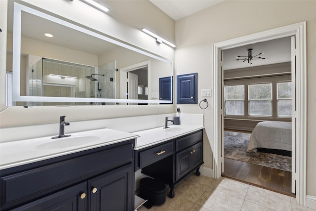 ensuite bathroom featuring double vanity, tile patterned floors, a sink, and ensuite bathroom