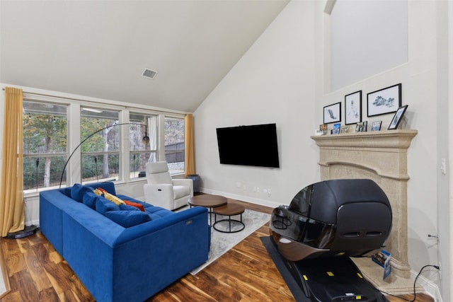 living area featuring high vaulted ceiling, dark wood-style flooring, visible vents, and baseboards