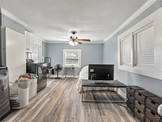 interior space featuring baseboards, light wood finished floors, washer / dryer, and crown molding