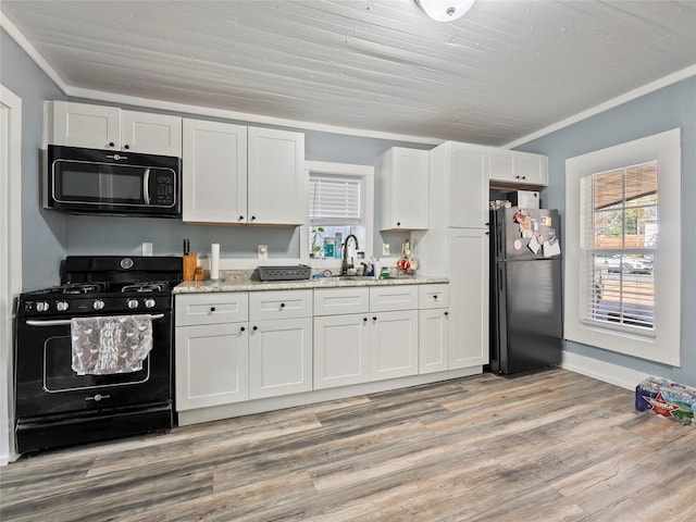 kitchen with black appliances, a sink, white cabinetry, and crown molding