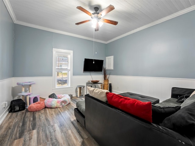 living room with a ceiling fan, wainscoting, crown molding, and wood finished floors