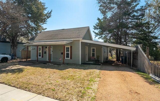 view of front of home featuring a carport, a front yard, driveway, and fence