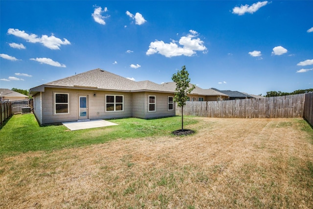 rear view of property with a patio, a lawn, and a fenced backyard