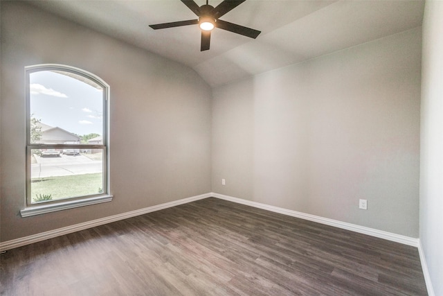 empty room with dark wood-style floors, lofted ceiling, baseboards, and a ceiling fan