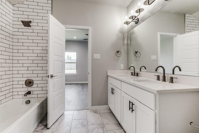 full bath with washtub / shower combination, marble finish floor, and a sink