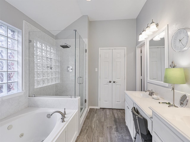 bathroom featuring wood finished floors, vanity, a closet, a tub with jets, and a stall shower