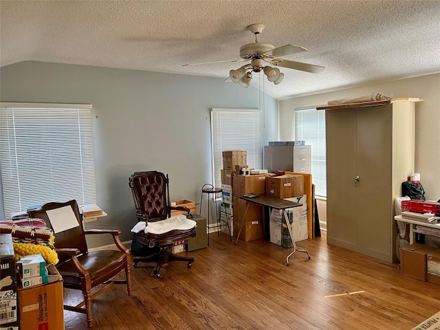 office area with a ceiling fan, vaulted ceiling, a textured ceiling, and wood finished floors