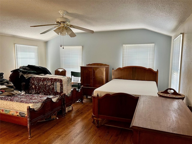 bedroom featuring lofted ceiling, a textured ceiling, a ceiling fan, and wood finished floors