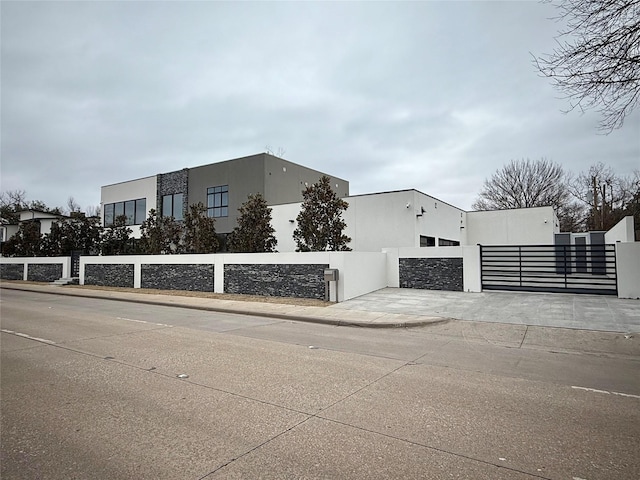 exterior space featuring fence, a gate, and stucco siding