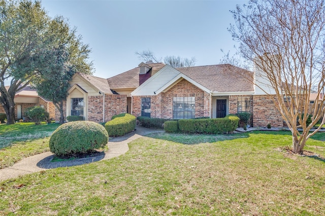 ranch-style home featuring brick siding and a front yard