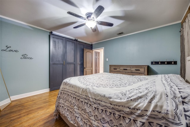 bedroom with baseboards, visible vents, a ceiling fan, ornamental molding, and wood finished floors