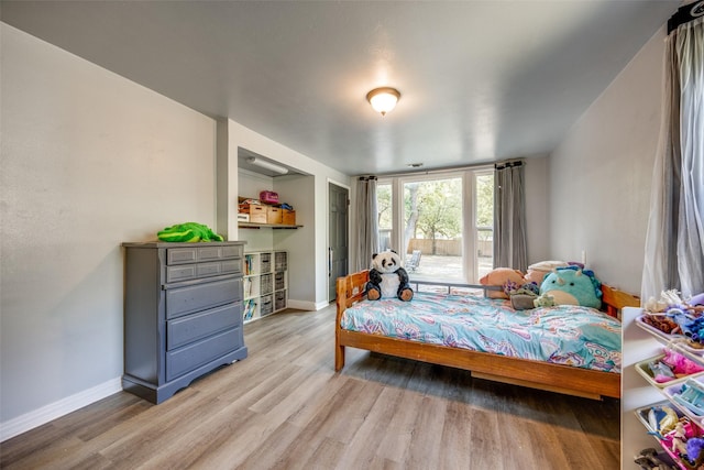 bedroom with light wood-type flooring and baseboards