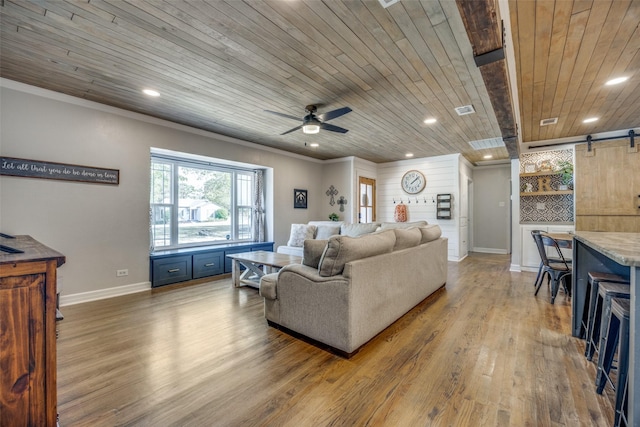 living area with crown molding, visible vents, a barn door, wood ceiling, and light wood-type flooring