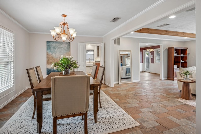 dining area with a chandelier, visible vents, crown molding, and baseboards