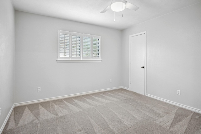 carpeted empty room with ceiling fan and baseboards