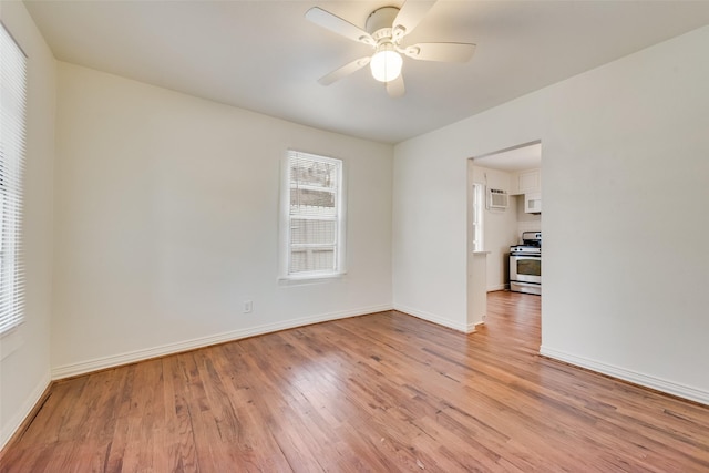 unfurnished room featuring a ceiling fan, light wood-style flooring, and baseboards