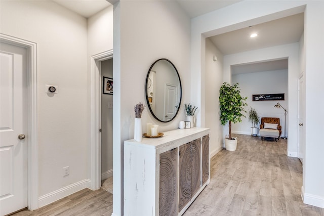 hallway featuring baseboards and light wood-style floors