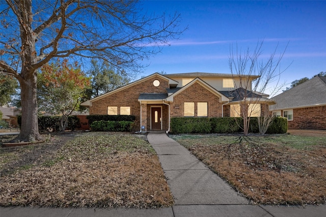 traditional-style house with fence and brick siding