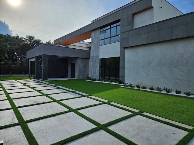 back of house featuring a yard and stucco siding