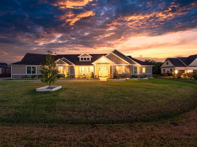 view of front of home featuring stone siding, a front lawn, and board and batten siding